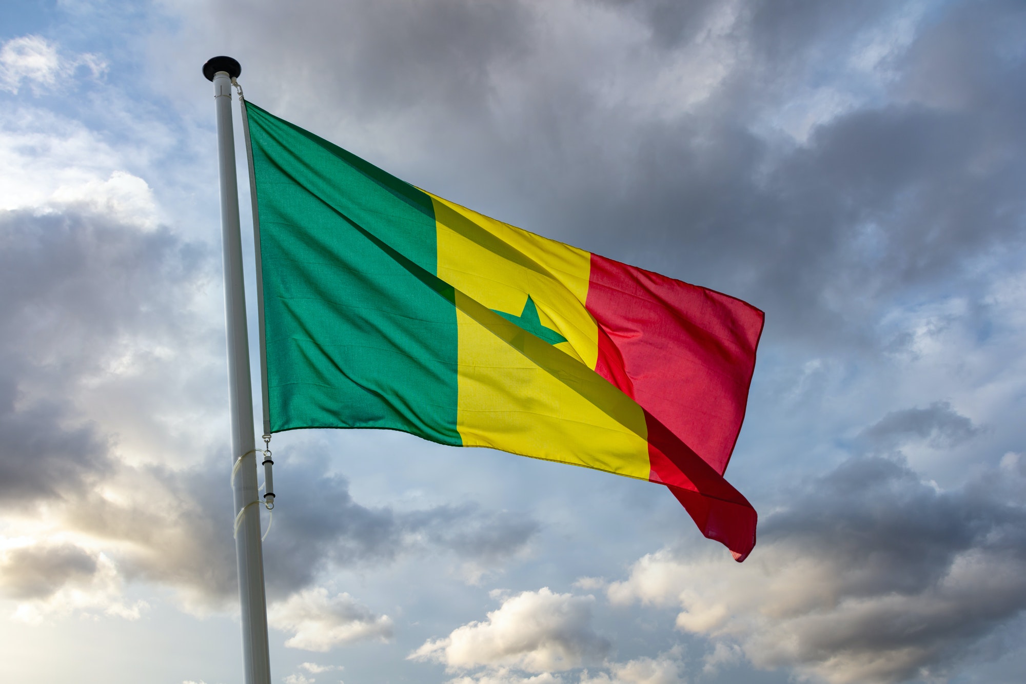 Senegal flag waving against cloudy sky